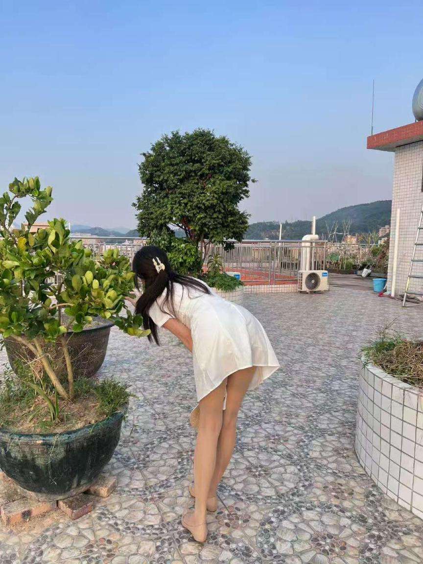 少妇在都市高层露台的夏日午后 Young woman on urban highrise terrace in summer afternoon