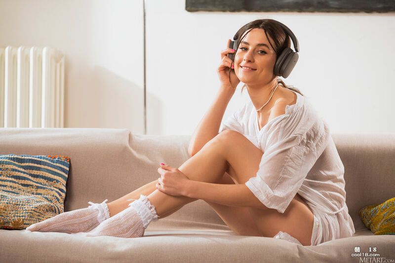 俏皮的女孩拉下她的内裤，在沙发上张开她光滑的臀部 Playful girl pulls down her panties and spreads her smooth ass on the couch