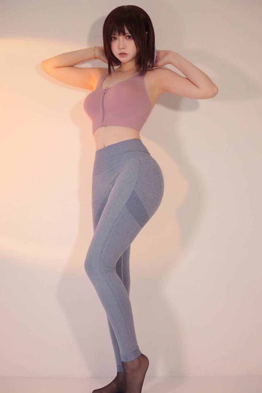 健身女性展现健康活力粉色运动上衣搭配灰色紧身裤的时尚魅力 Fitness wom