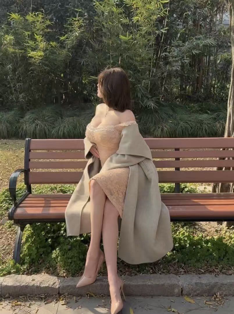 午后阳光下公园长椅上的优雅女士 Elegant lady sitting on